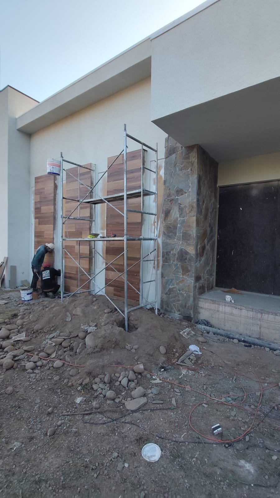 Remodelación de fachada con revestimiento de madera y piedra